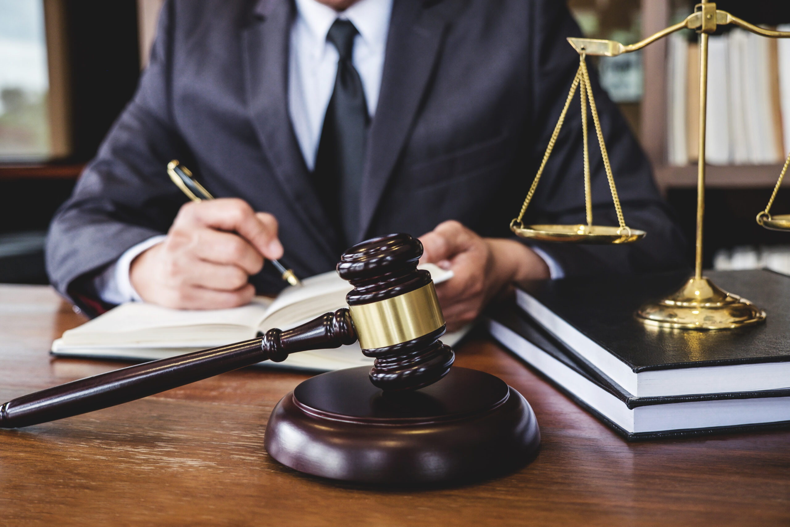 Lawyer behind desk with gavel 1 scaled 1