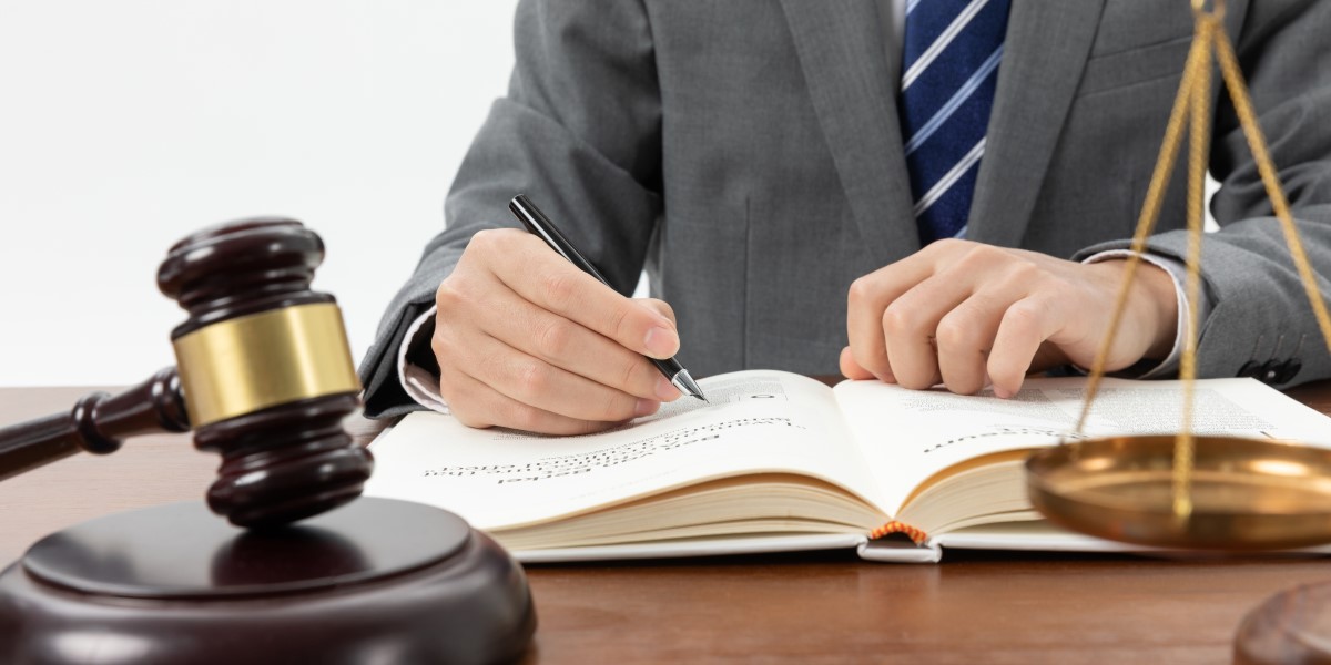 closeup shot person writing book with gavel table